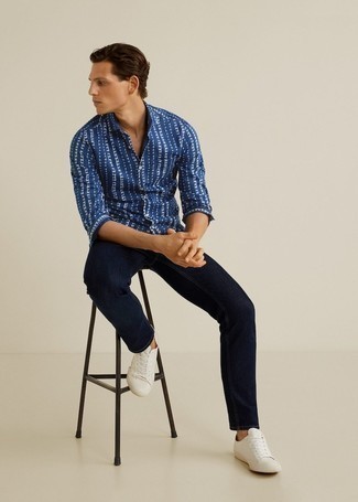 Look alla moda per uomo: Camicia a maniche lunghe stampata blu scuro e bianca, Jeans blu scuro, Sneakers basse di tela bianche