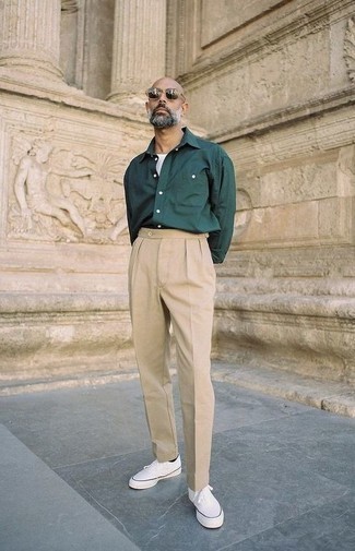 Moda uomo anni 40: Combina una camicia a maniche lunghe verde scuro con chino beige per un look trendy e alla mano. Per un look più rilassato, opta per un paio di sneakers basse di tela bianche.