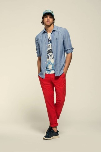 Look alla moda per uomo: Camicia a maniche lunghe in chambray blu, T-shirt girocollo stampata bianca e blu scuro, Chino rossi, Scarpe sportive nere