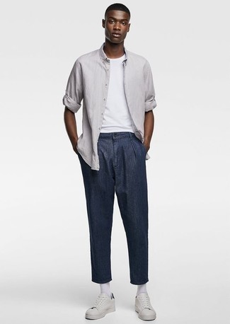 Look alla moda per uomo: Camicia a maniche lunghe grigia, T-shirt girocollo bianca, Chino blu scuro, Sneakers basse in pelle bianche