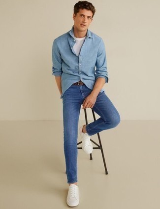 Come indossare e abbinare jeans blu con sneakers basse di tela bianche quando fa caldo: Potresti combinare una camicia a maniche lunghe azzurra con jeans blu per un look semplice, da indossare ogni giorno. Sneakers basse di tela bianche sono una validissima scelta per completare il look.