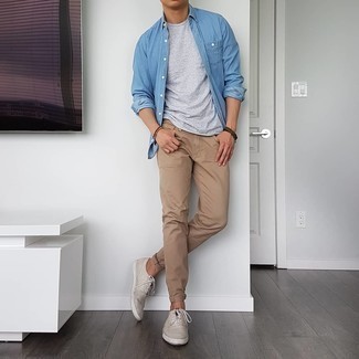 Quale jeans indossare con sneakers basse beige: Coniuga una camicia a maniche lunghe in chambray blu con jeans per un look trendy e alla mano. Rifinisci questo look con un paio di sneakers basse beige.