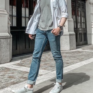 Come indossare e abbinare una t-shirt girocollo grigia: Combina una t-shirt girocollo grigia con jeans blu per un look trendy e alla mano. Sneakers basse in pelle grigie sono una validissima scelta per completare il look.