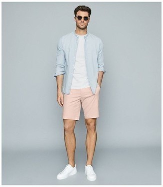 Come indossare e abbinare pantaloncini rosa: Prova ad abbinare una camicia a maniche lunghe azzurra con pantaloncini rosa per vestirti casual. Sneakers basse di tela bianche sono una gradevolissima scelta per completare il look.