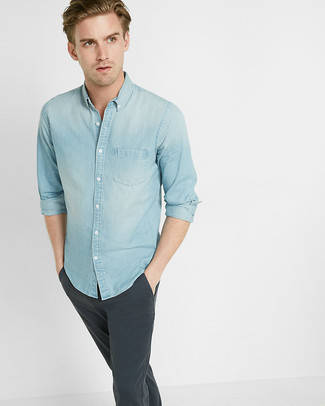Come indossare e abbinare una camicia di jeans azzurra quando fa caldo in modo casual: Per un outfit quotidiano pieno di carattere e personalità, metti una camicia di jeans azzurra e chino grigio scuro.