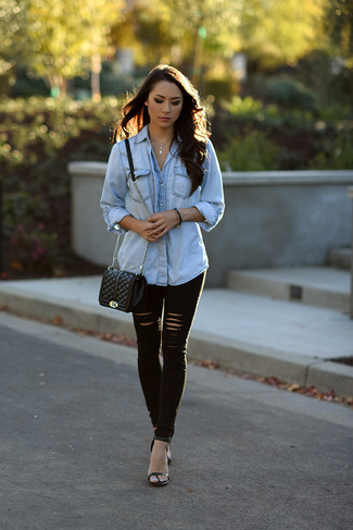 Look alla moda per donna: Camicia di jeans azzurra, Jeans aderenti strappati neri, Sandali con tacco in pelle neri, Borsa a tracolla in pelle trapuntata nera