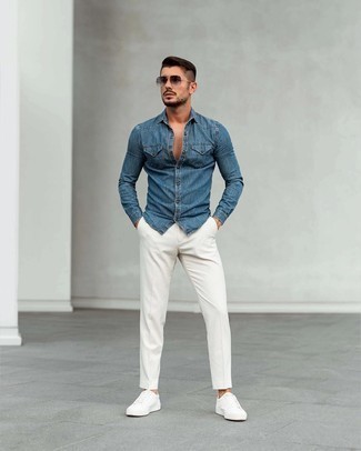Come indossare e abbinare chino bianchi quando fa caldo: Combina una camicia di jeans blu con chino bianchi per un look trendy e alla mano. Questo outfit si abbina perfettamente a un paio di sneakers basse di tela bianche.