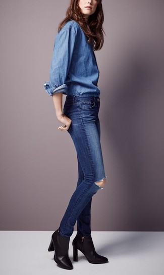 Come indossare e abbinare jeans aderenti blu scuro con una camicia di jeans blu scuro in modo smart-casual: Abbina una camicia di jeans blu scuro con jeans aderenti blu scuro per creare un look raffinato e glamour. Stivaletti in pelle neri sono una eccellente scelta per completare il look.