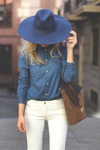 Look alla moda per donna: Camicia di jeans blu scuro, Jeans aderenti bianchi, Borsa shopping in pelle scamosciata marrone, Borsalino di lana blu scuro
