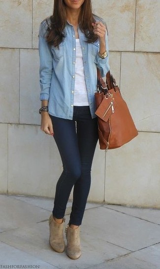 Look alla moda per donna: Camicia di jeans azzurra, Canotta bianca, Jeans aderenti blu scuro, Stivaletti in pelle scamosciata beige