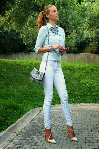 Look alla moda per donna: Camicia di jeans azzurra, Pantaloni skinny bianchi, Décolleté in pelle marrone chiaro, Borsa a tracolla in pelle con stampa serpente grigia