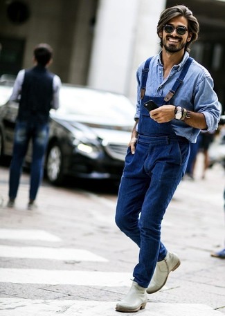 Look alla moda per uomo: Camicia di jeans azzurra, Salopette di jeans blu, Stivali chelsea in pelle grigi, Occhiali da sole neri