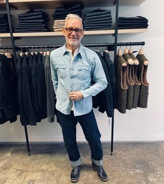 Moda uomo anni 50: Vestiti con una camicia di jeans azzurra e jeans blu scuro per un look semplice, da indossare ogni giorno. Calza un paio di stivali chelsea in pelle neri per mettere in mostra il tuo gusto per le scarpe di alta moda.