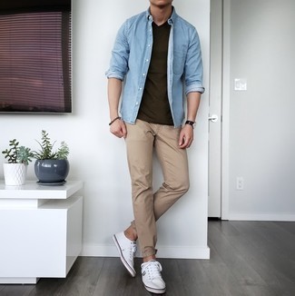 Quale camicia di jeans indossare con chino marrone chiaro per un uomo di 30 anni in modo casual: Abbina una camicia di jeans con chino marrone chiaro per affrontare con facilità la tua giornata. Sneakers basse di tela bianche sono una validissima scelta per completare il look.