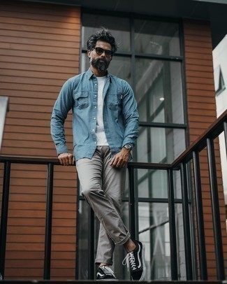 Come indossare e abbinare una camicia di jeans azzurra con jeans grigi: Potresti abbinare una camicia di jeans azzurra con jeans grigi per un look semplice, da indossare ogni giorno. Sneakers basse di tela nere e bianche sono una valida scelta per completare il look.