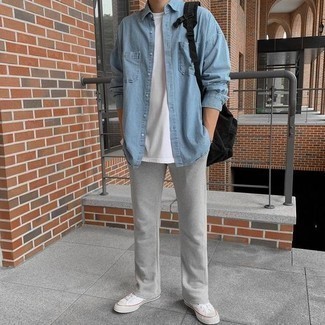 Trend da uomo 2024 in estate 2024: Indossa una camicia di jeans azzurra con pantaloni sportivi grigi per un look perfetto per il weekend. Sneakers basse di tela bianche sono una valida scelta per completare il look. Con quest'outfit estivo non puoi sbagliare.