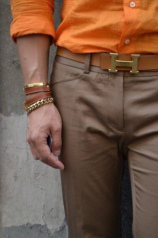 Look alla moda per uomo: Camicia elegante arancione, Pantaloni eleganti marroni, Cintura in pelle marrone, Bracciale in pelle marrone