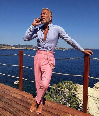 Come indossare e abbinare una camicia elegante azzurra per un uomo di 50 anni: Metti una camicia elegante azzurra e pantaloni eleganti rosa per un look elegante e di classe.