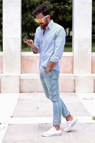 Come indossare e abbinare jeans azzurri quando fa caldo in modo smart-casual: Mostra il tuo stile in una camicia elegante a righe verticali bianca e blu con jeans azzurri per vestirti casual. Per distinguerti dagli altri, opta per un paio di sneakers basse bianche.