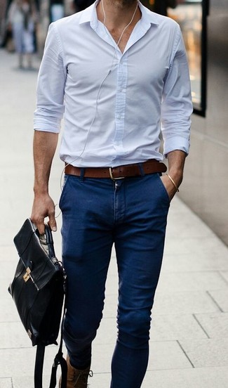 Look alla moda per uomo: Camicia elegante azzurra, Jeans aderenti blu scuro, Stivali casual in pelle marroni, Ventiquattrore in pelle nera