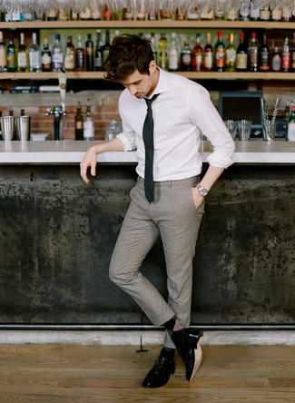 Look alla moda per uomo: Camicia elegante bianca, Pantaloni eleganti di lana grigi, Scarpe brogue in pelle nere, Cravatta nera
