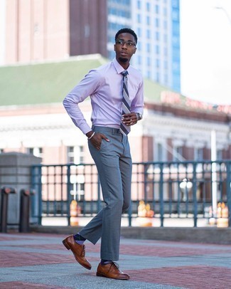 Come indossare e abbinare una cravatta grigia: Combina una camicia elegante viola chiaro con una cravatta grigia per essere sofisticato e di classe. Calza un paio di scarpe brogue in pelle marroni per un tocco più rilassato.