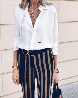 Moda donna anni 60 in modo formale: Punta su una camicia elegante di chiffon bianca e pantaloni skinny a righe verticali neri se preferisci uno stile ordinato e alla moda.