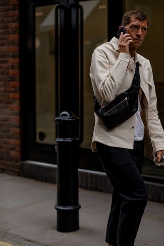 Moda uomo anni 40 in primavera 2024 in modo casual: Indossa una camicia giacca beige e chino neri per un look da sfoggiare sul lavoro. Questo è il look must have per questa stagione primaverile.