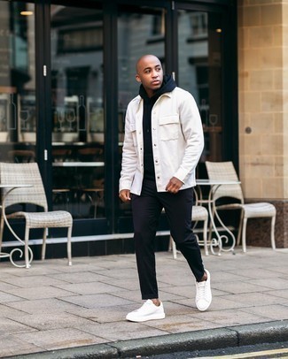 Look alla moda per uomo: Camicia giacca bianca, Felpa con cappuccio nera, Chino neri, Sneakers basse in pelle bianche