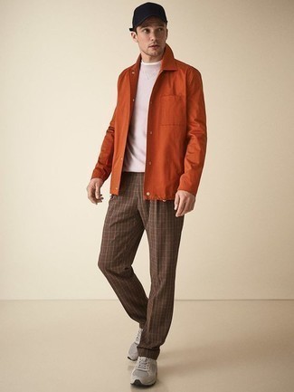 Look alla moda per uomo: Camicia giacca arancione, Maglione girocollo beige, Chino scozzesi marroni, Scarpe sportive grigie