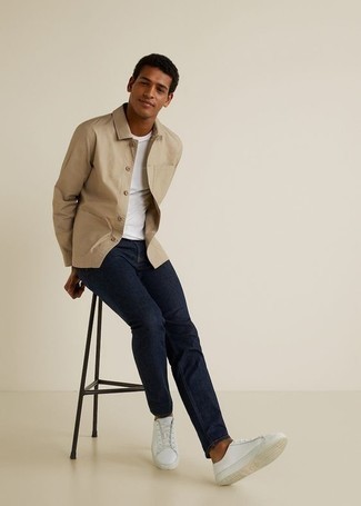 Quale jeans indossare con una camicia giacca beige per un uomo di 20 anni: Per un outfit quotidiano pieno di carattere e personalità, metti una camicia giacca beige e jeans. Aggiungi un tocco fantasioso indossando un paio di sneakers basse in pelle bianche.