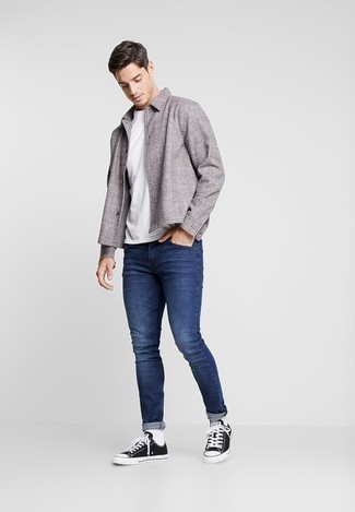 Come indossare e abbinare jeans aderenti: Scegli una camicia giacca scozzese grigia e jeans aderenti per vestirti casual. Perfeziona questo look con un paio di sneakers basse di tela nere e bianche.