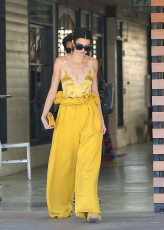 Come indossare e abbinare una pochette in pelle gialla in modo smart-casual: Opta per una canotta di seta gialla e una pochette in pelle gialla per un'atmosfera casual-cool.