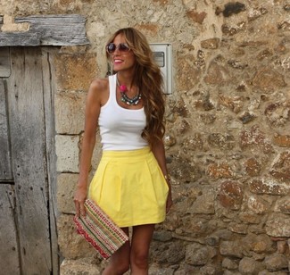Look alla moda per donna: Canotta bianca, Gonna a pieghe gialla, Pochette ricamata multicolore, Occhiali da sole marroni