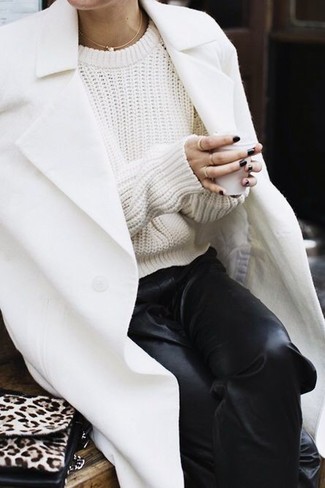 Come indossare e abbinare un maglione a trecce bianco quando fa freddo: Un maglione a trecce bianco e pantaloni sportivi in pelle neri trasmettono una sensazione di semplicità e spensieratezza.
