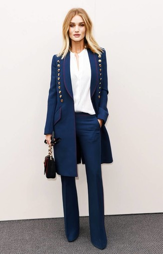 Moda donna anni 30 in modo formale: Combina un cappotto blu scuro con pantaloni a campana blu scuro per un look elegante ma non troppo appariscente.
