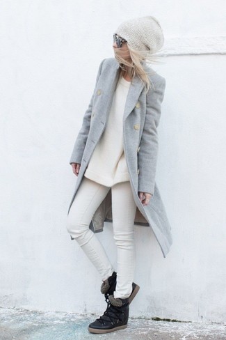 Look alla moda per donna: Cappotto grigio, Maglione girocollo bianco, Jeans aderenti bianchi, Sneakers con zeppa in pelle nere