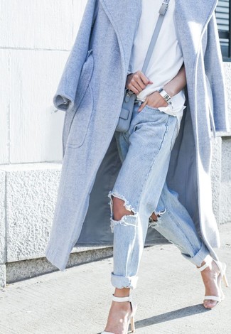 Quale cappotto indossare con jeans azzurri per una donna di 30 anni quando fa gelo: Combina un cappotto con jeans azzurri per un outfit inaspettato. Sandali con tacco in pelle bianchi sono una interessante scelta per completare il look.