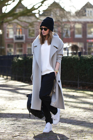 Look alla moda per donna: Cappotto grigio, T-shirt girocollo bianca, Pantaloni sportivi neri, Scarpe sportive bianche