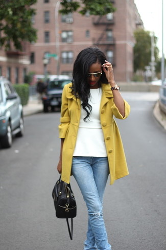 Look alla moda per donna: Cappotto senape, Top peplo bianco, Jeans strappati azzurri, Borsa shopping in pelle nera