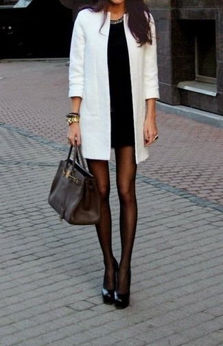 Look alla moda per donna: Cappotto bianco, Vestito aderente nero, Décolleté in pelle neri, Borsa shopping in pelle marrone scuro