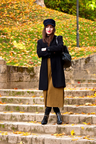 Look alla moda per donna: Cappotto nero, Vestito di maglia senape, Jeans aderenti neri, Stivaletti in pelle neri