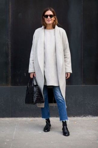Look alla moda per donna: Cappotto grigio, Vestito di maglia grigio, Jeans blu, Stivaletti in pelle neri