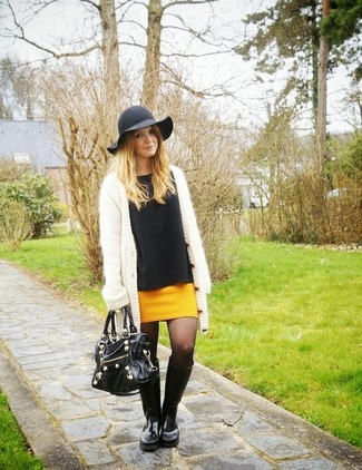 Look alla moda per donna: Cardigan aperto morbido bianco, Camicetta manica lunga nera, Minigonna senape, Stivali di gomma neri