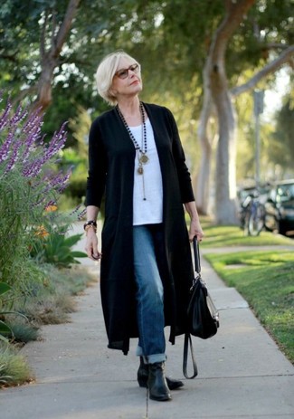 Moda donna anni 50: Scegli un outfit composto da un cardigan aperto nero e jeans boyfriend blu per un pigro brunch domenicale. Rifinisci questo look con un paio di stivaletti in pelle neri.