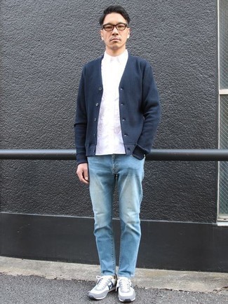 Quale jeans indossare con scarpe sportive bianche e blu scuro per un uomo di 40 anni: Per un outfit quotidiano pieno di carattere e personalità, opta per un cardigan blu scuro e jeans. Per un look più rilassato, mettiti un paio di scarpe sportive bianche e blu scuro.
