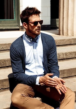 Come indossare e abbinare un cardigan blu scuro per un uomo di 30 anni in modo smart-casual: Indossa un cardigan blu scuro con chino marrone chiaro per un look semplice, da indossare ogni giorno.