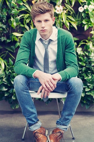 Look alla moda per uomo: Cardigan verde, Camicia a maniche lunghe bianca, Jeans aderenti blu, Scarpe brogue in pelle marroni
