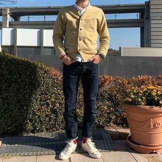 Trend da uomo 2021: Coniuga un cardigan beige con jeans blu scuro per affrontare con facilità la tua giornata. Per distinguerti dagli altri, prova con un paio di sneakers basse di tela bianche.