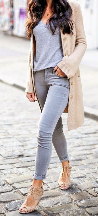 Quale jeans aderenti indossare con una t-shirt con scollo a v grigia quando fa caldo in modo smart-casual: Prova a combinare una t-shirt con scollo a v grigia con jeans aderenti per un look semplice, da indossare ogni giorno. Sandali con tacco in pelle scamosciata marrone chiaro sono una valida scelta per completare il look.